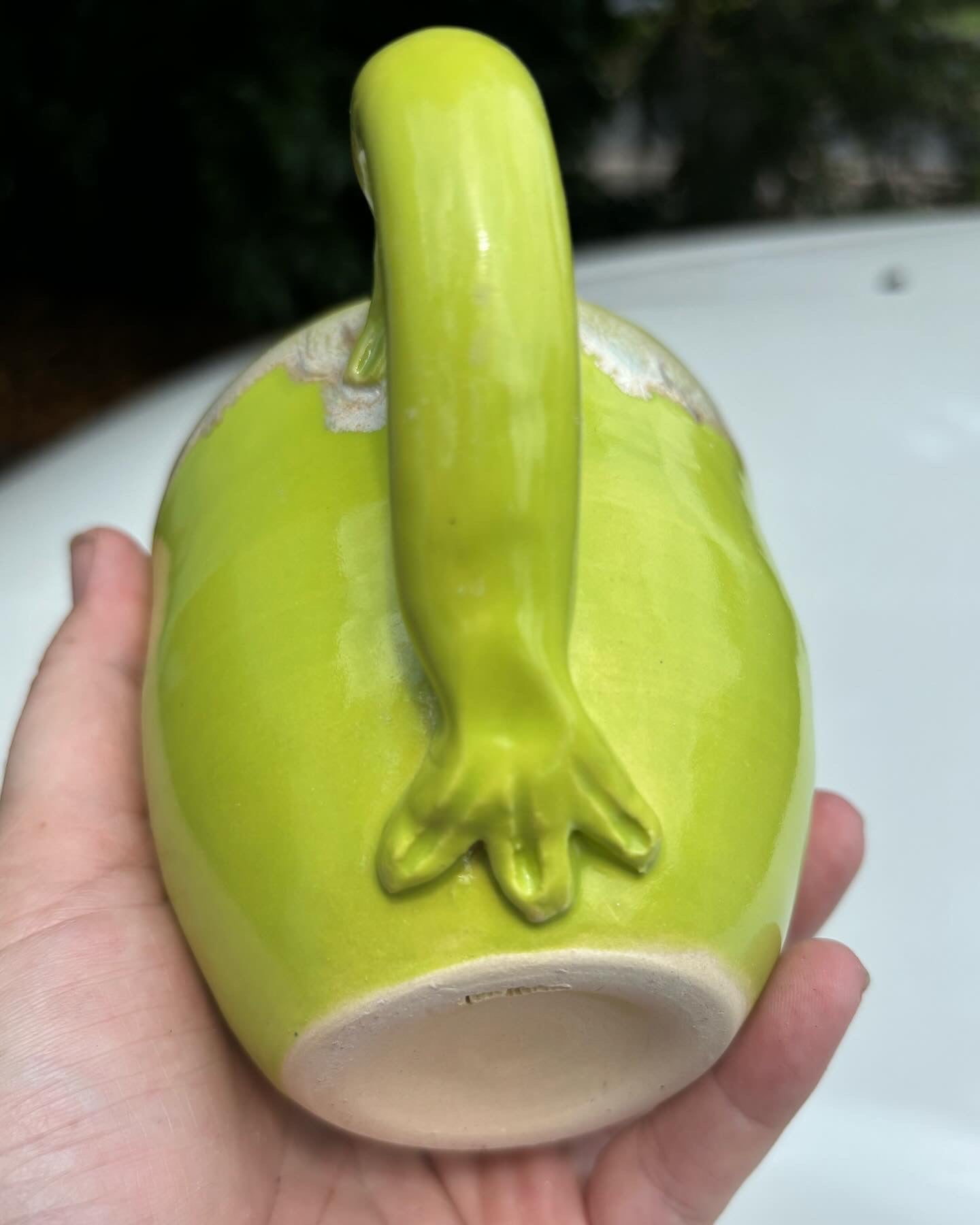 Photo of a bright green ceramic mug's hand detailed handle.