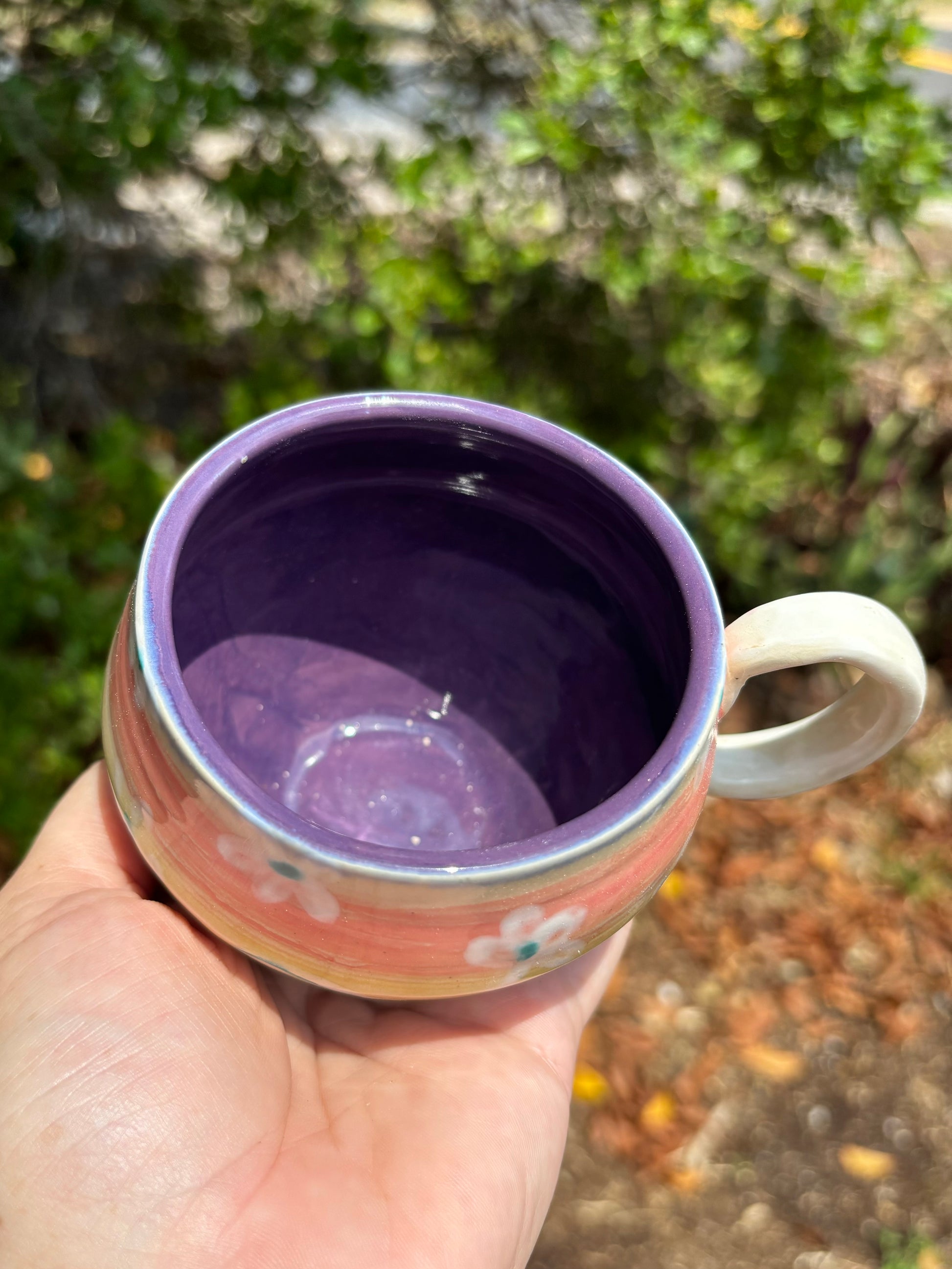 Photo of a colorful mug with a bright purple glaze inside.