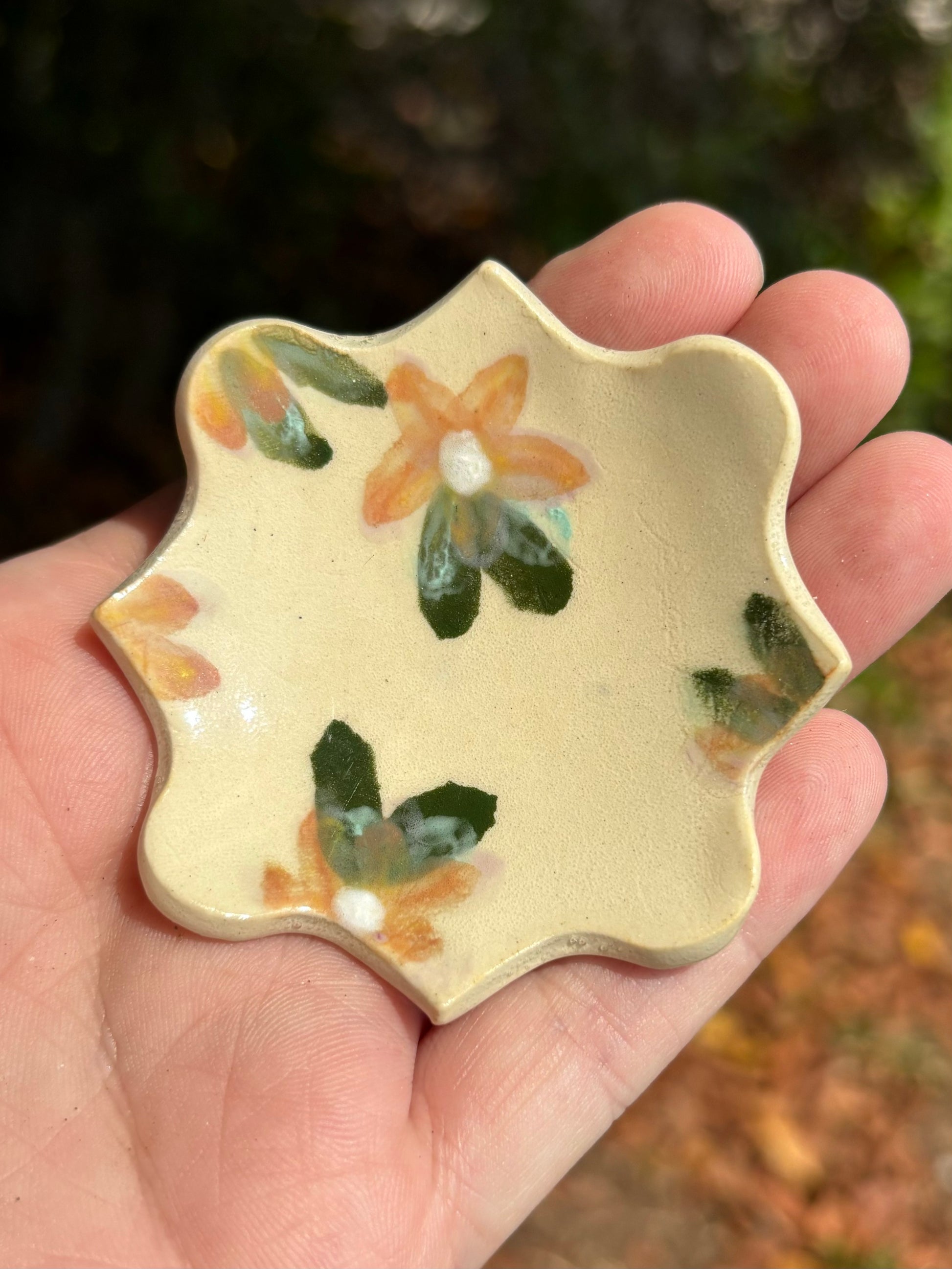 Photo of a small decorative dish with bright orange florals.