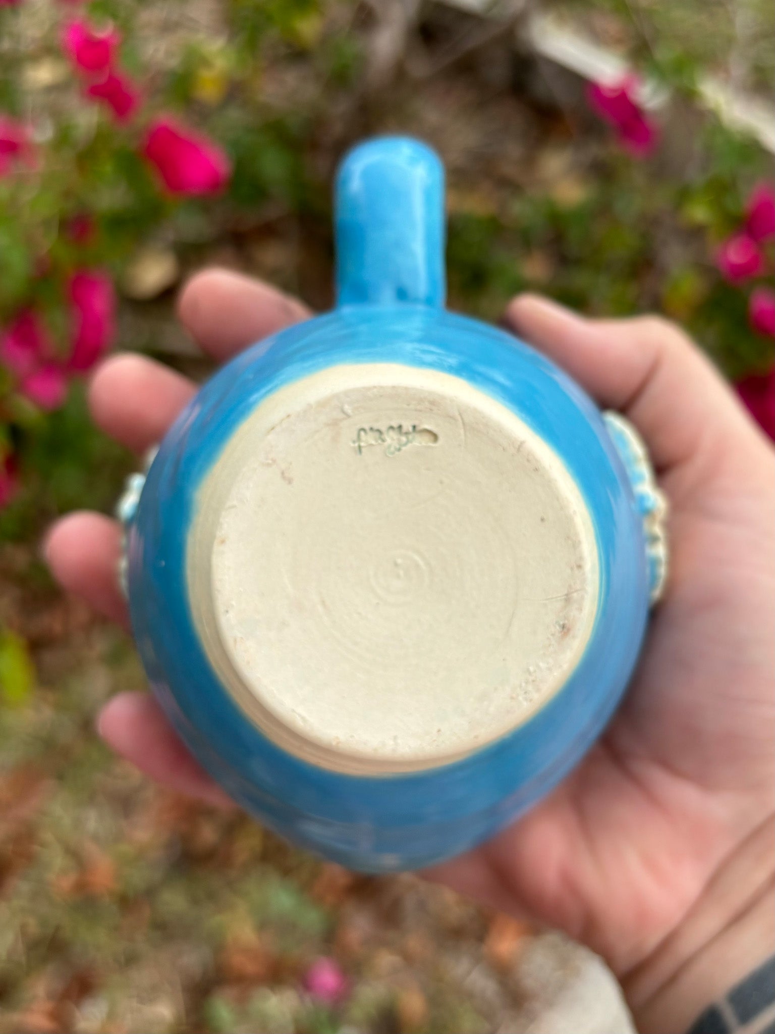 Photo of the bottom of a blue ceramic mug.