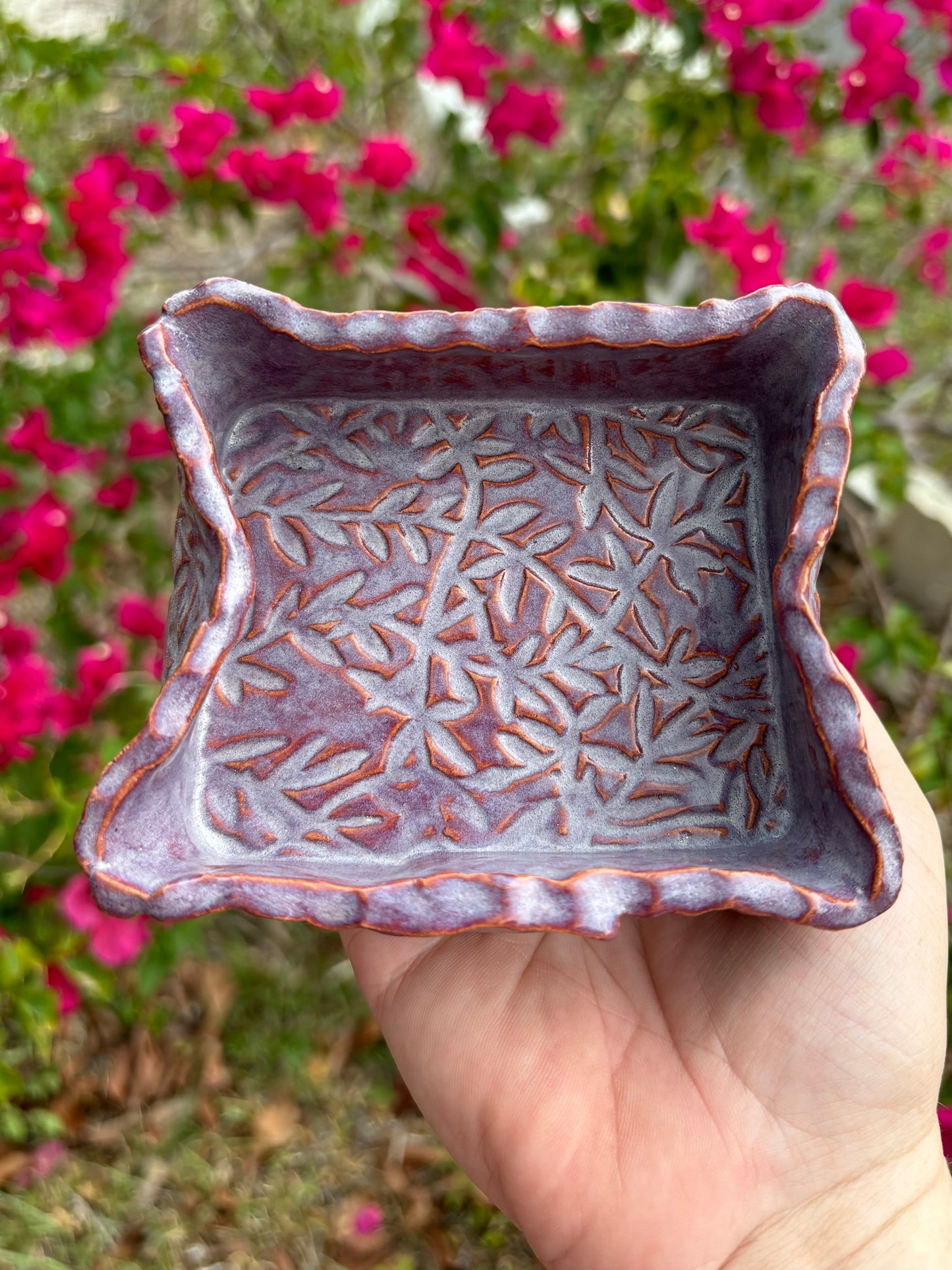 Photo of a dusty purple ceramic box with floral vines imprinted into the clay.