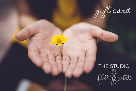 Photo of outstretched hands cupping a yellow flower.